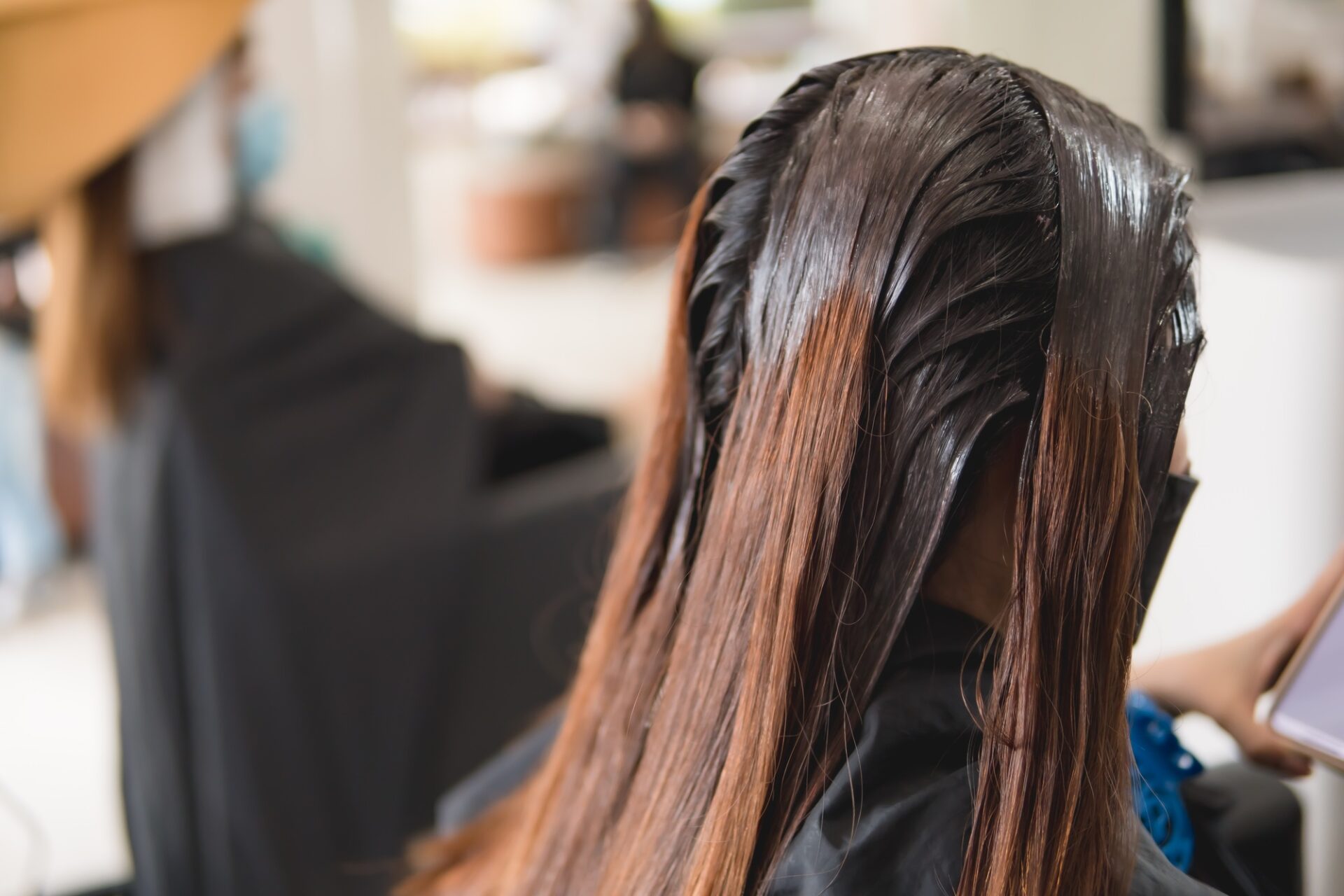 Gros plan de la tête pendant la coloration des cheveux dans le salon de beauté.